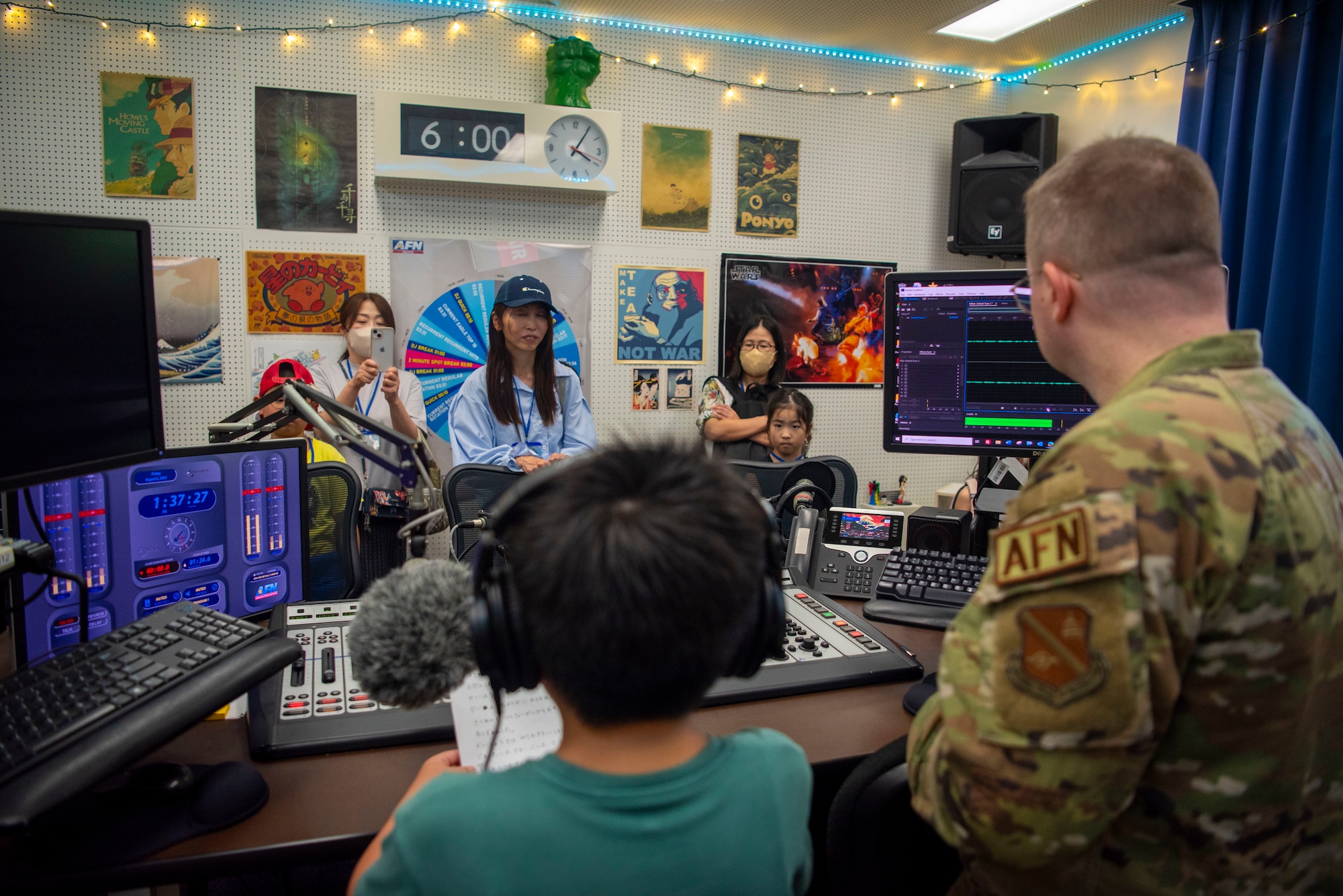 A Misawa Friendship Tour participant practice speaking English while learning about the radio from U.S. Air Force Staff Sgt. Benjamin Bugenig, American Forces Network video noncommissioned officer in charge, at Misawa Air Base, Japan, Aug. 2, 2024.