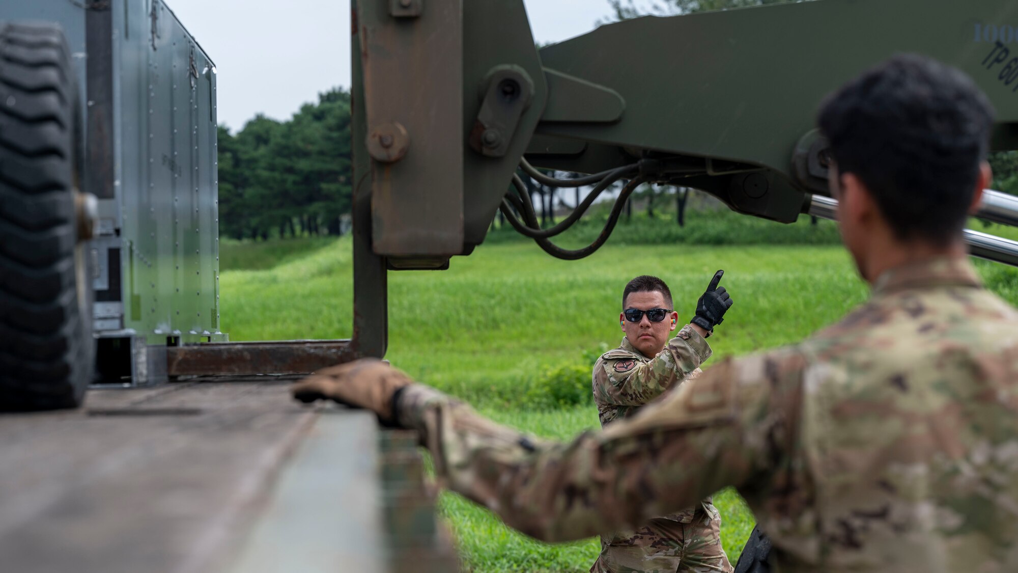 U.S. Air Force Senior Airman David Vargos Figueroa, 51st Logistics Readiness Squadron ground transportation journeyman, directs a forklift operator during a training event at Osan Air Base, Republic of Korea, Aug 8, 2024. Airmen from the 51st LRS and 51st Munitions Squadron worked together to carry out the assigned training tasks, enabling the “Fight Tonight” mission. (U.S. Air Force photo by Senior Airman Sabrina Fuller-Judd)