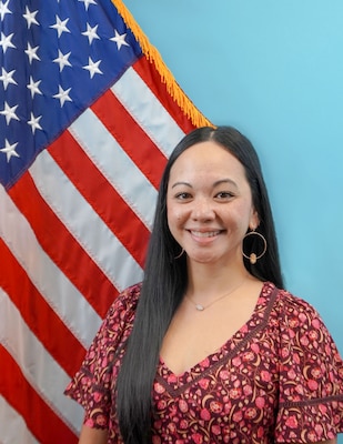 Maria Parker and behind her is the American flag and a blue background.