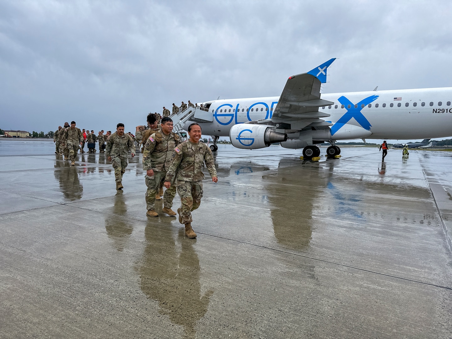 Alaska Army Guard Staff Sgt. Serita Harvey, an infantryman with Bravo Company, 1st Battalion, 297th Infantry Regiment, walks on to the flight line with Sgt. Thanakorn Nuanphong and Spc. Anthony Shaw behind her at Joint Base Elmendorf-Richardson, Alaska, Aug. 10, 2024, after a nine-month deployment to Kuwait. Approximately 100 “Bison” Company Soldiers deployed in November as part of Operation Spartan Shield.