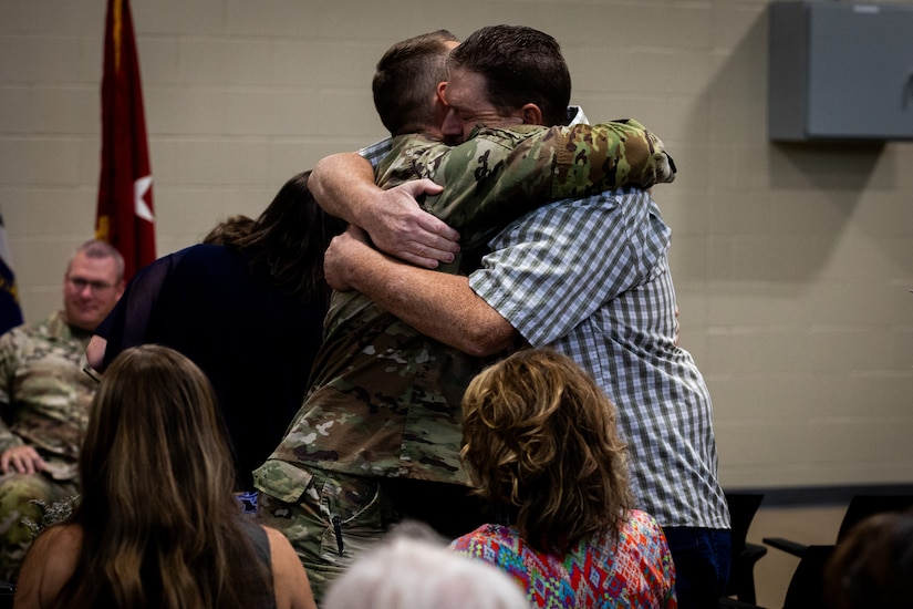 U.S. Army Capt. Luke Sims, an engineer officer with the 613th Engineer Facilities Detachment, 149th Maneuver Enhancement Brigade, hugs a family member at the Springfield Army National Guard Armory in Springfield, Kentucky on August 5, 2024. Approximately 15 Soldiers of the 613 FACDET are departing for Kuwait for base directorate of public works mission at Camp Buehring. (U.S. Army National Guard photo by Andy Dickson)