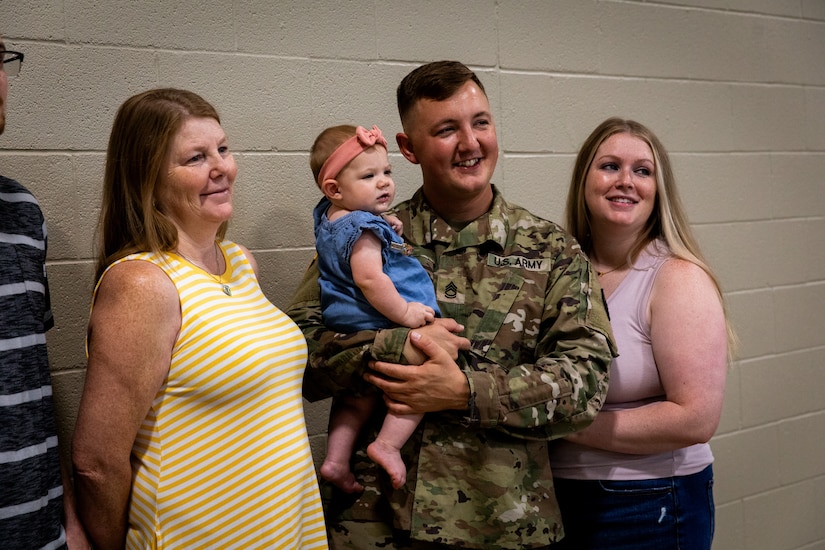 Sgt. 1st Class Robert Moll, an engineer withe the 613th Engineer Facilities Detachment, 149th Maneuver Enhancement Brigade, poses for photos with his family and friends at the Springfield Army National Guard Armory in Springfield, Kentucky on August 5, 2024. Approximately 15 Soldiers of the 613 FACDET are departing for Kuwait for base directorate of public works mission at Camp Buehring. (U.S. Army National Guard photo by Andy Dickson)