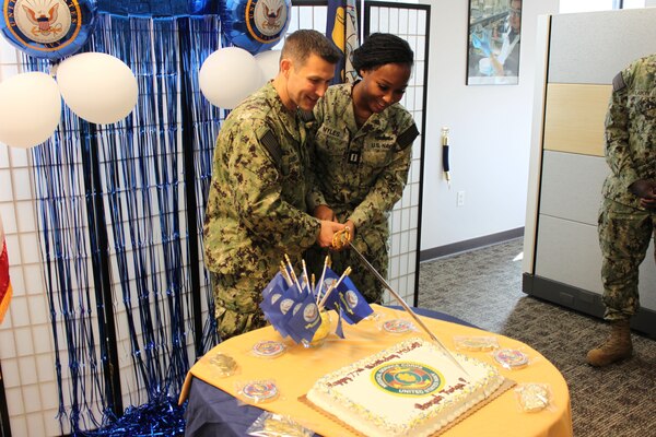 Capt. Barnes and Lt. Myles happily slice the ceremonial cake to kick off the eating portion of the festivities in celebrating the MSC 77th birthday at NMRLC Detachment Fort Detrick, Frederick, MD.