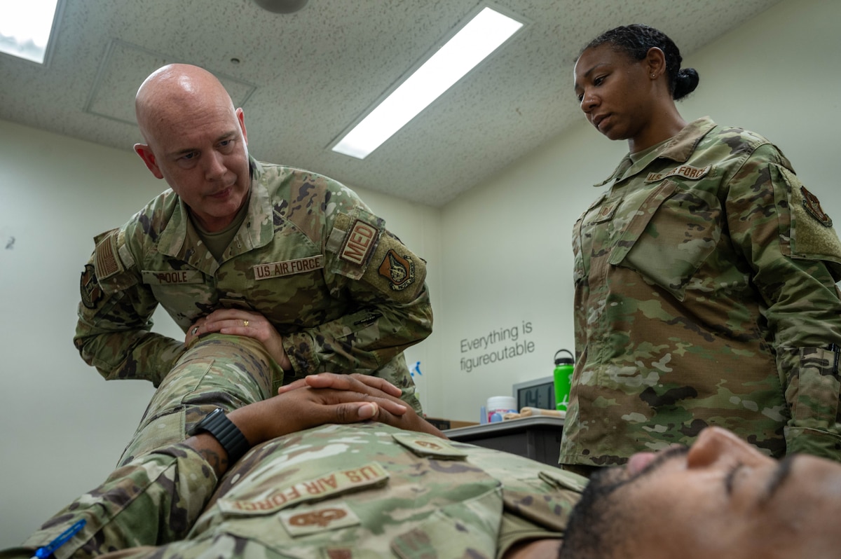 A physical therapist treats a service member.