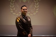 Chief Warrant Officer 3 Troy Capehart poses on stage after graduating the 420T Talent Acquisition Technician training course.