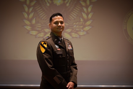 U.S. Army Soldier poses for photograph on stage