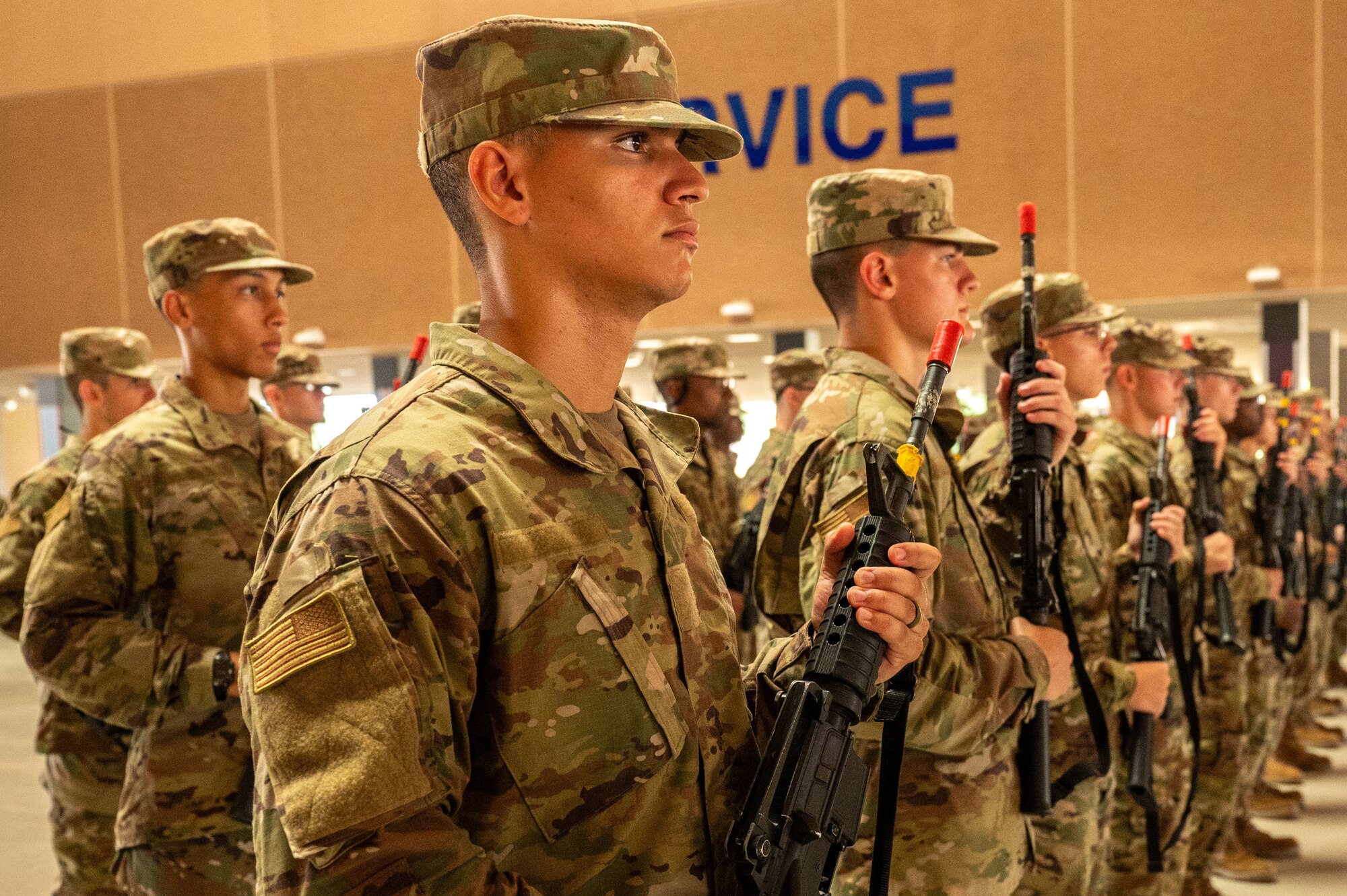 U.S. Air Force trainees stand in formation holding practice weapons.