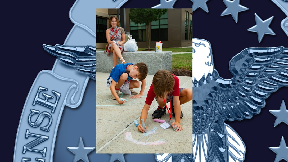 Kids color on sidewalk with chalk.