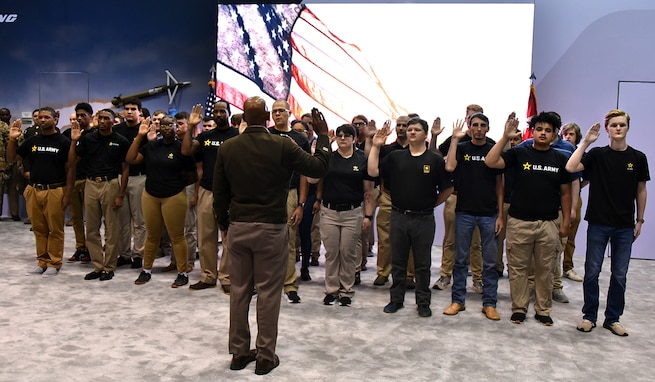 Lt. Gen. Sean A. Gainey, commanding general of U.S. Army Space and Missile Defense Command, administers the oath of enlistment to 22 future Soldiers and 12 future Sailors at a swearing in ceremony, Aug. 7, during the 2024 Space and Missile Defense Symposium at the Von Braun Center in Huntsville, Ala. (U.S. Army photo by Allen Meeks)