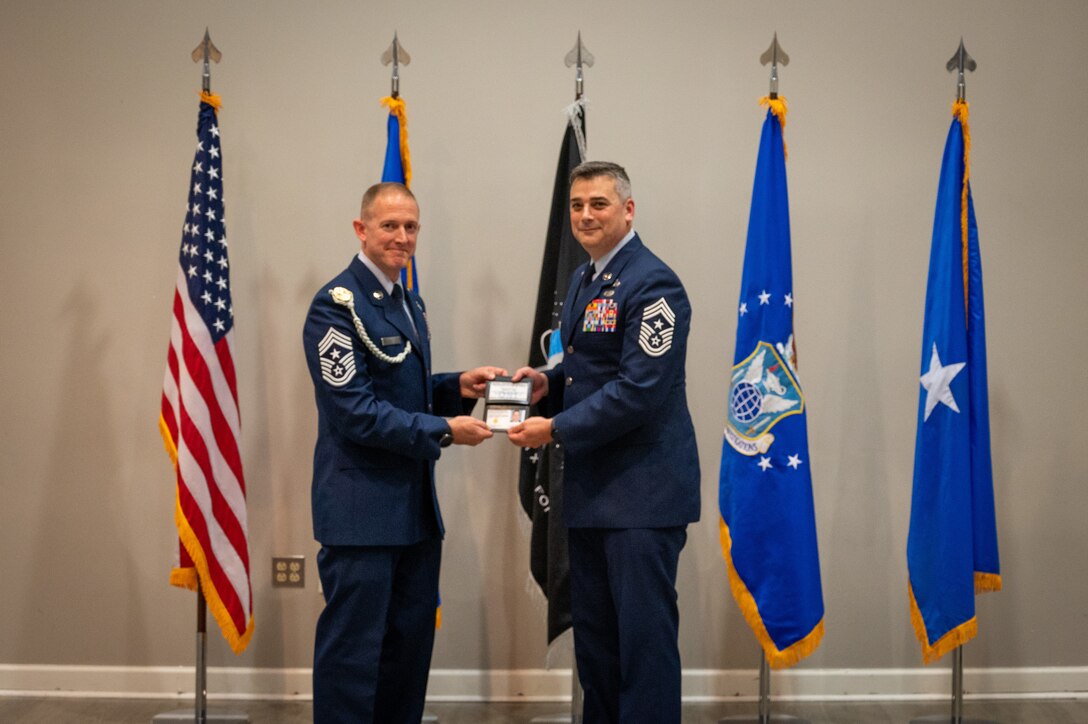 Chief Master Sgt. James Hoy, OSI’s command chief, accepts the No. 9 badge from Chief Master Sgt. Gregg Gow, his predecessor, during the change of responsibility ceremony at Fort Belvoir, Virginia, on August 2, 2024.