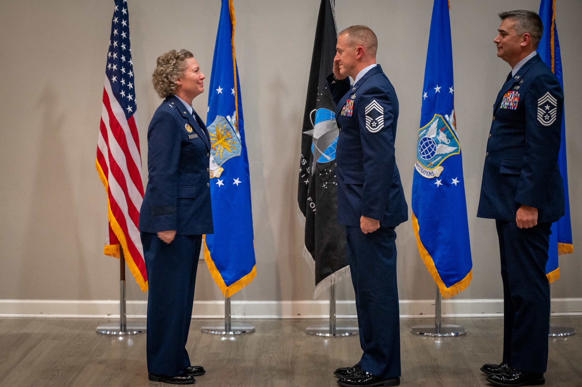 Chief Master Sgt. James Hoy salutes Brig. Gen. Amy Bumgarner, OSI’s commander, during the change of responsibility ceremony at Fort Belvoir, Virginia, August 2, 2024, becoming OSI’s command chief.
