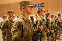 U.S. Air Force trainees stand in formation holding practice weapons.