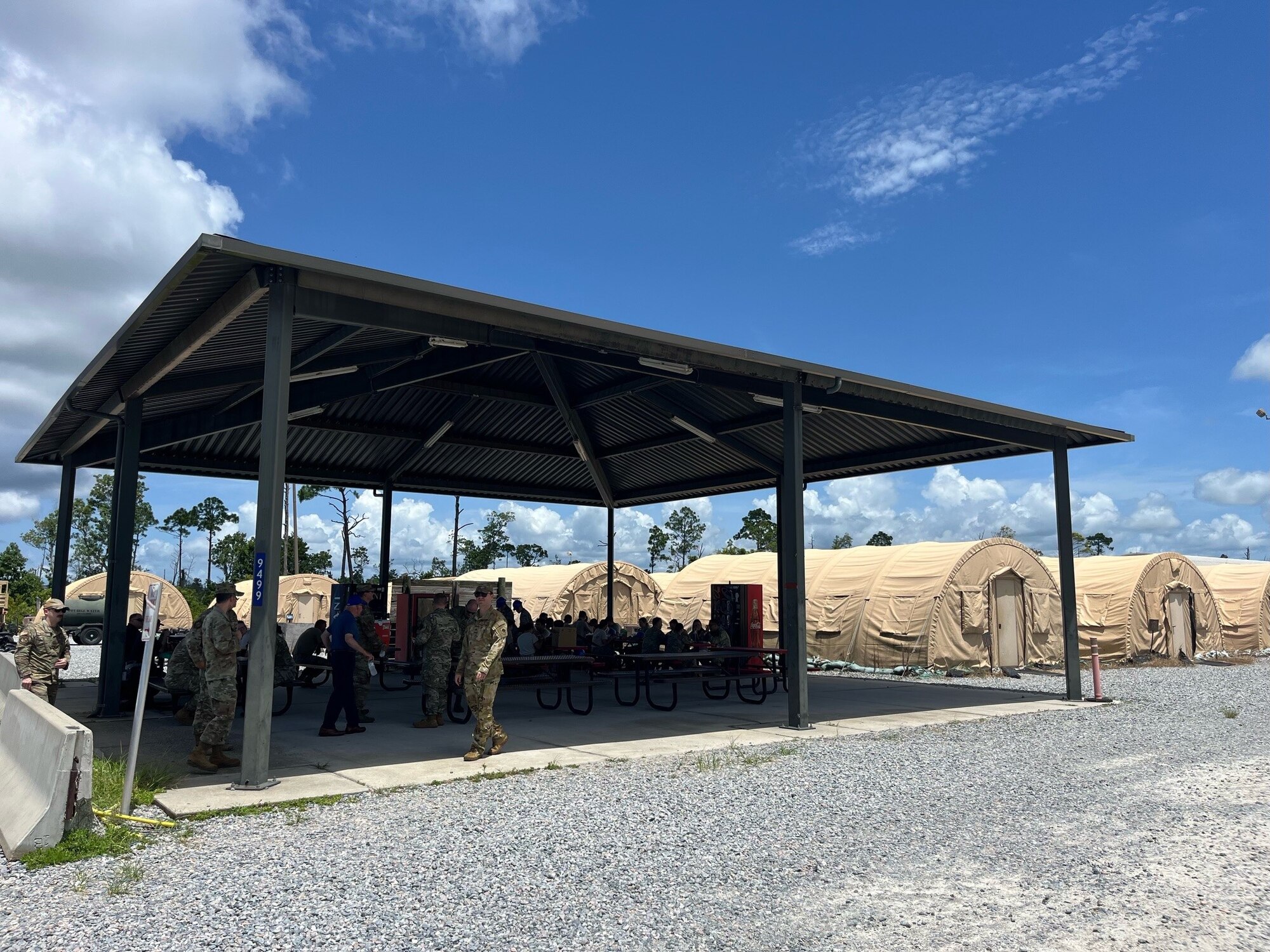 Members from the 12th Air Task Force A-Staff sit under an outdoors gazebo surrounded by tents