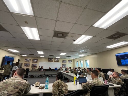 Members from the 12th Air Task Force A-Staff listen intently while sitting at a table