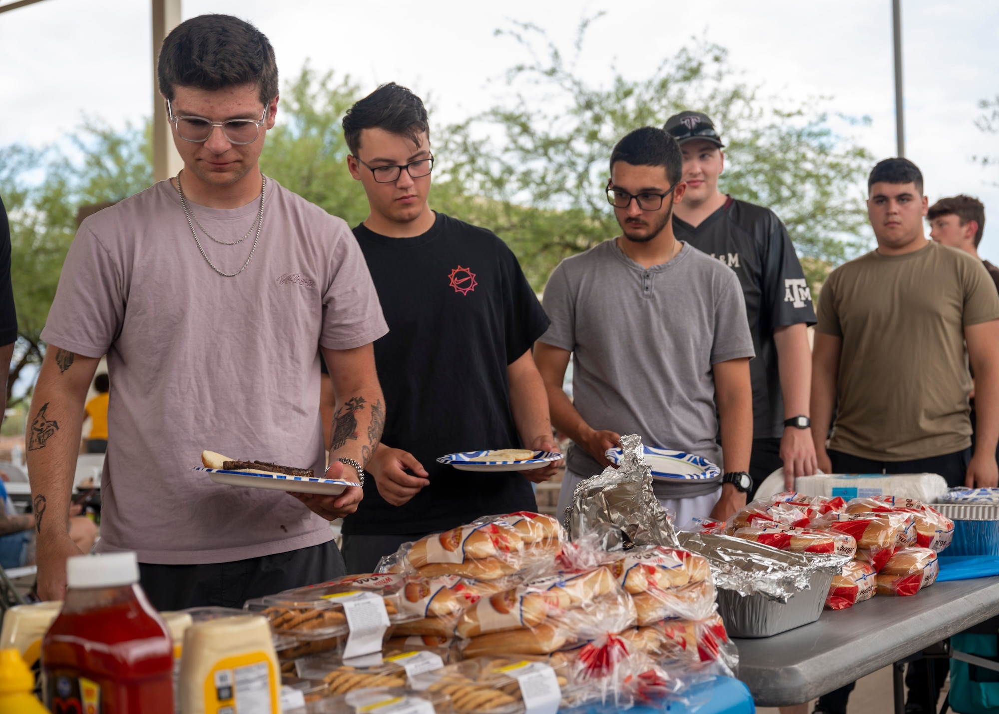 U.S. Airmen get food during the Summer Dorm Bash at Davis-Monthan Air Force Base, Ariz., Aug. 9, 2024. Airmen who attended the event were provided free food and games and the opportunity to connect with one another. (U.S. Air Force photo by Airman 1st Class William Finn V)