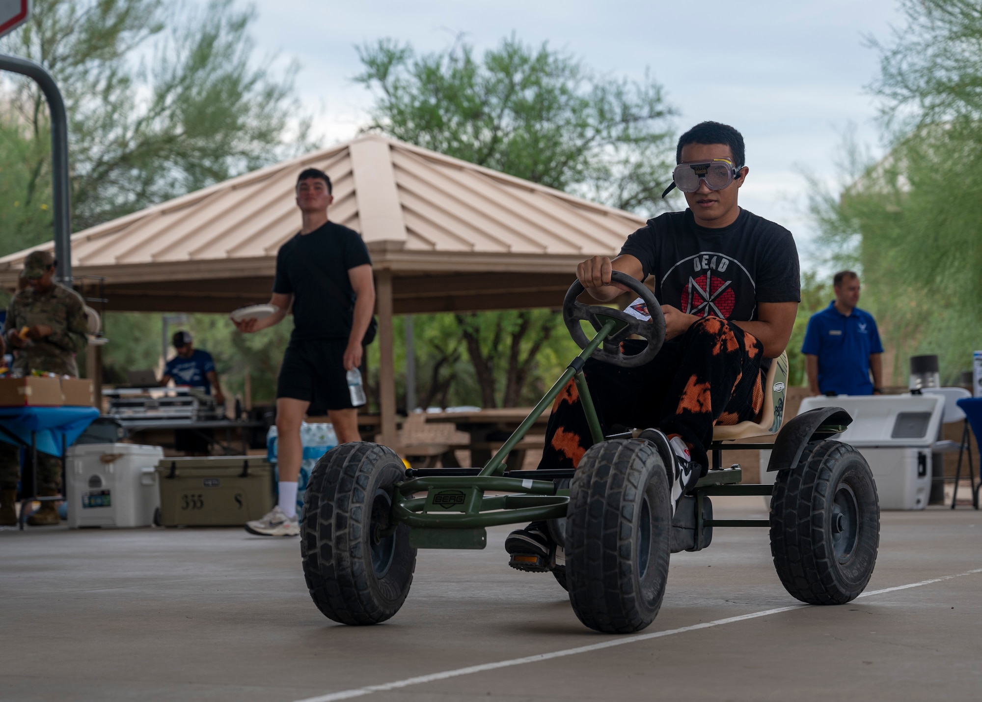 A U.S. Airman rides a pedal kart while wearing goggles that simulate drunkenness during the Summer Dorm Bash at Davis-Monthan Air Force Base, Ariz., Aug. 9, 2024. The Alcohol and Drug Abuse Prevention and Treatment Program provided the kart and goggles to educate Airmen on the dangers of drunk driving. (U.S. Air Force photo by Airman 1st Class William Finn V)