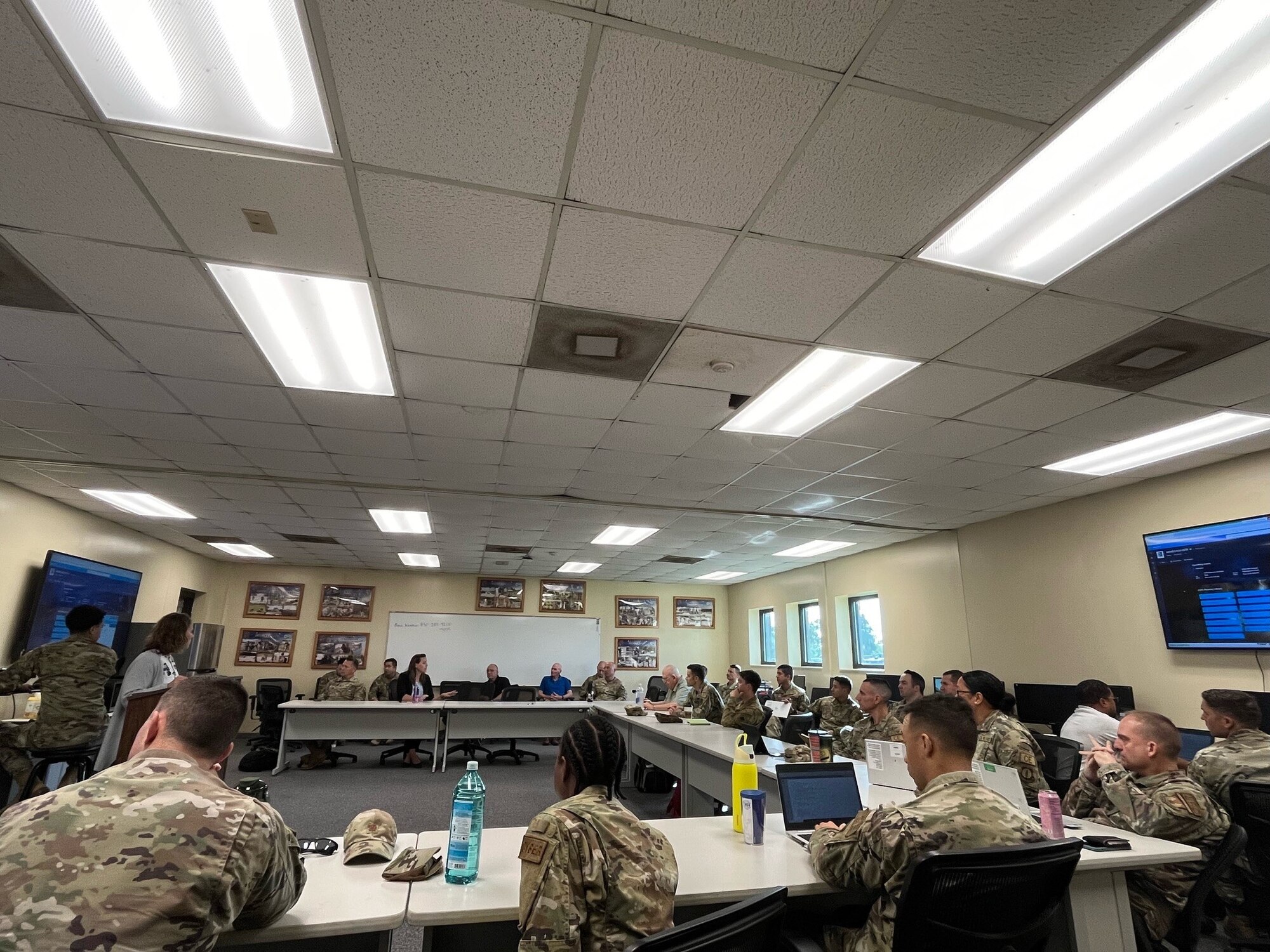 Members from the 12th Air Task Force A-Staff listen intently while sitting at a table