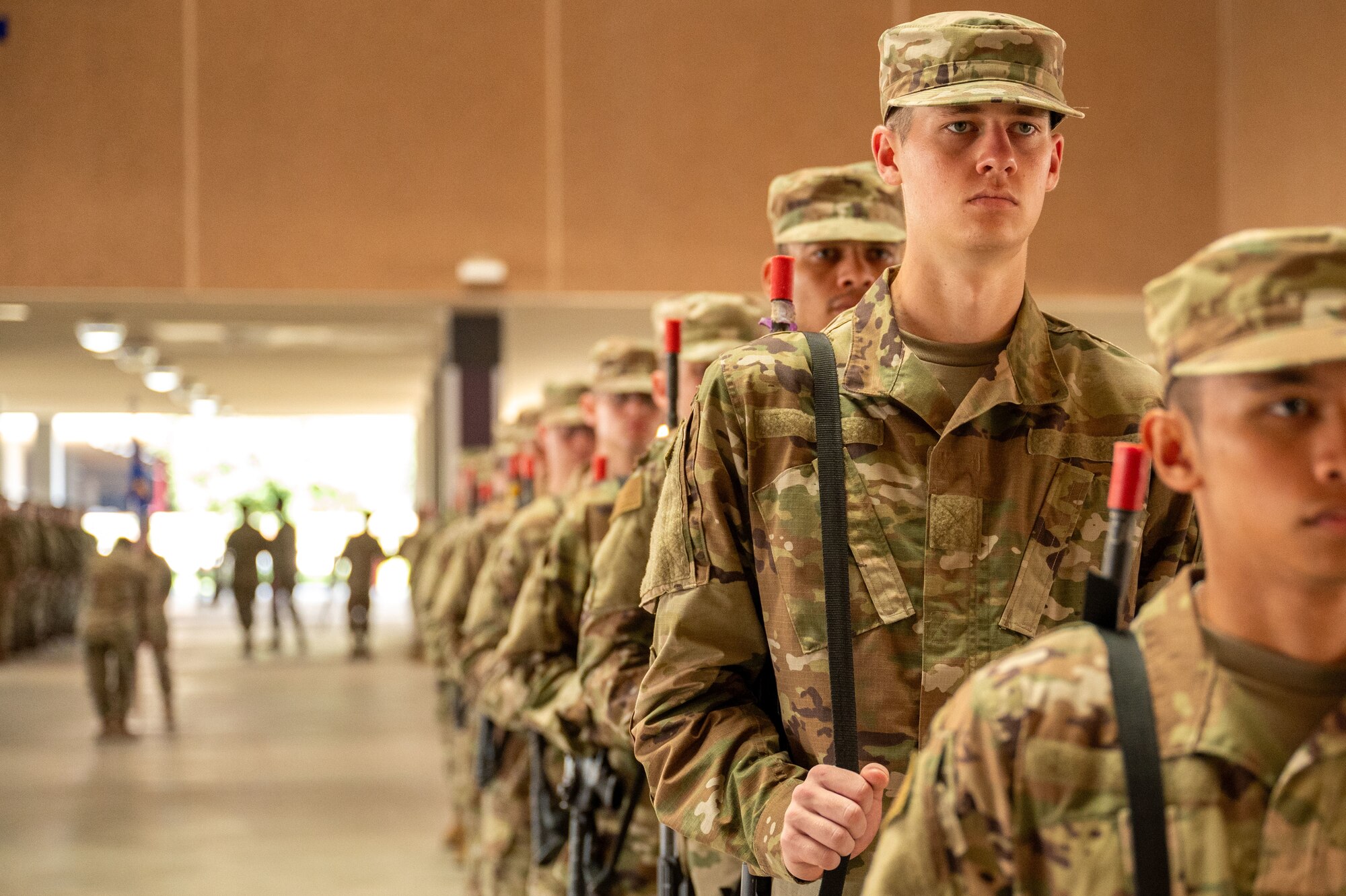 U.S. Air Force trainees stand in formation holding practice weapons.