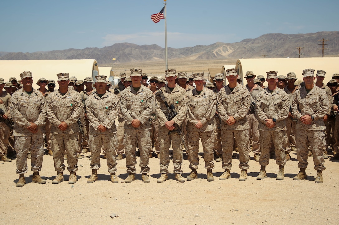 U.S. Marine Corps Maj. Gen. David L. Odom (right), a Hartsville, South Carolina native and the commanding general of 2d Marine Division (MARDIV), and Sgt. Maj. Joseph Mendez (left), a Brooklyn, New York native and sergeant major of 2d MARDIV, pose for photo with Marines and Sailors with 1st Battalion, 2d Marine Regiment, 2d Marine Division, after an awards ceremony on Marine Corps Air-Ground Combat Center, Twentynine Palms, California, Aug. 11, 2024. Servicemembers with 1st Battalion, 2d Marine Regiment, 2d MARDIV were awarded a Navy and Marine Corps Commendation Medal for rendering aid to a Marine during a live fire exercise, ultimately saving his life. (U.S. Marine Corps photo by Lance Cpl. Weston Lindstrom)