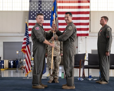 Col. Andrew M. Weidner, left, passes the 149th Fighter Squadron guidon to Lt. Col. Peter “Sly” Liggieri.