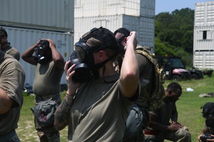 Airman putting gas mask on during training.