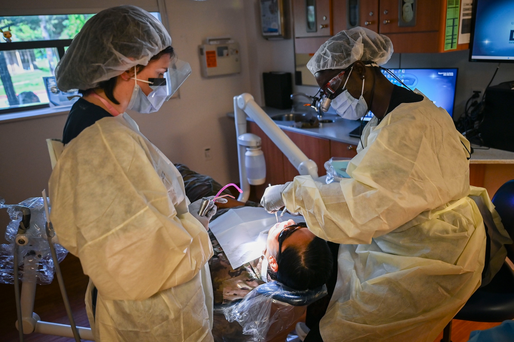 Senior Airman Anya Leech, left, 8th Operational Medical Readiness Squadron dental technician, assists U.S. Air Force Capt. Brittany Osei-Owusu, 8th OMRS officer in charge of the support element, during a dental procedure at Kunsan Air Base, Republic of Korea.