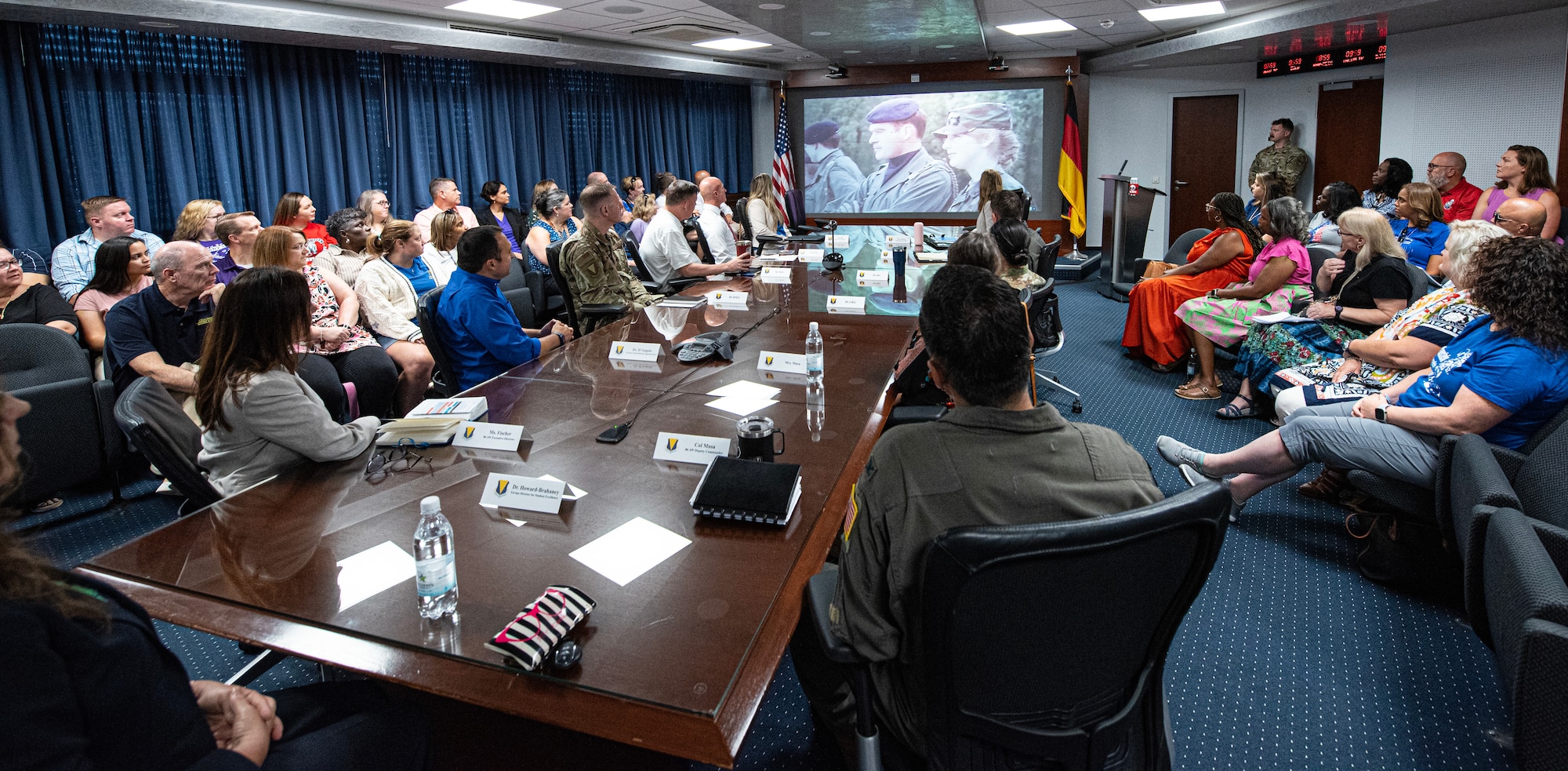 U.S. Air Force 86th Airlift Wing members and Department of Defense Education Activity educators watch a video about the 86 AW mission during an immersion tour at Ramstein Air Base, Germany, Aug. 9, 2024. DODEA teachers participated in an immersion tour to help them understand the 86 AW mission and how their work assists Airmen accomplish the mission by caring for and educating their children. (U.S. Air Force photo by Senior Airman Thomas Karol)