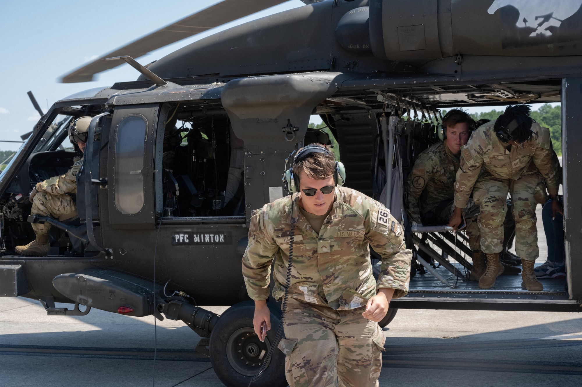 Air Force cadets exit a helicopter.