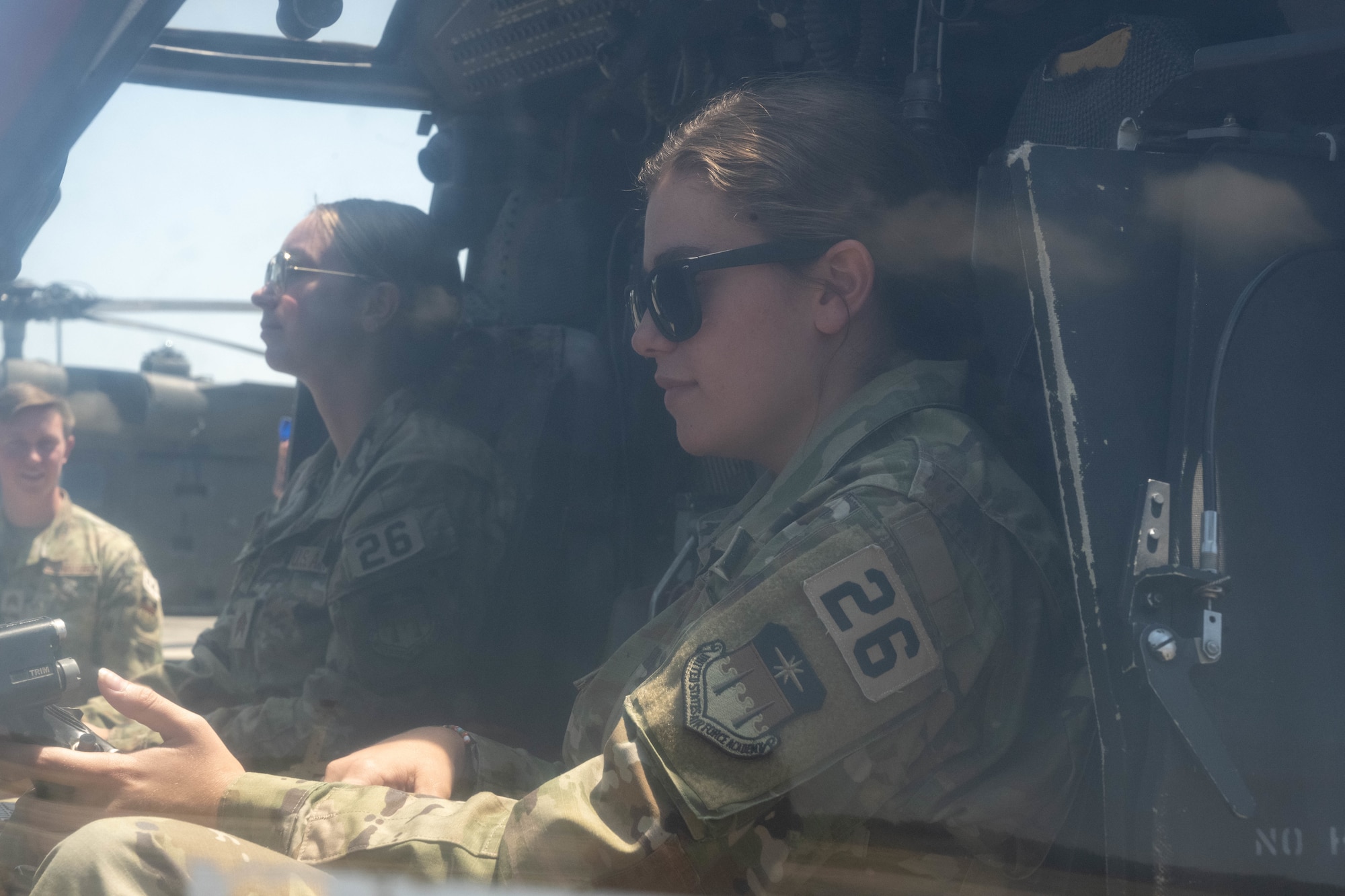Air Force cadets sits in the pilot seat of a helicopter.
