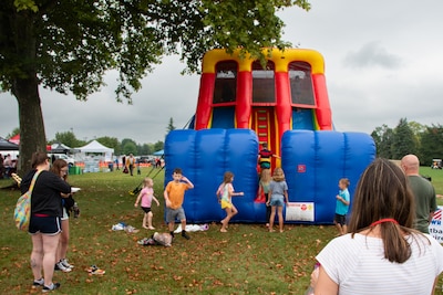 Children climb on a blue, red and yellow inflatable slide.