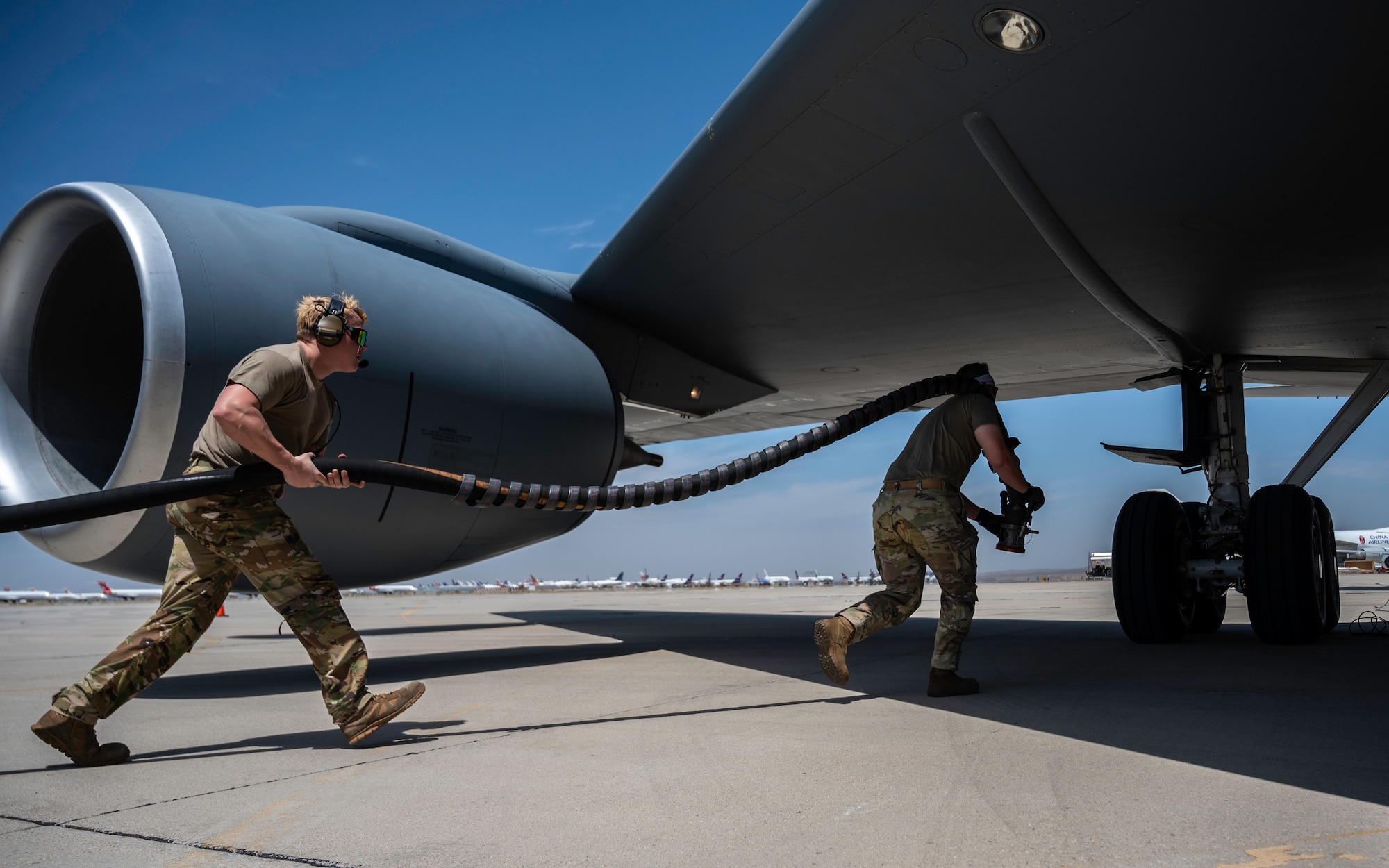 U.S. Air Force Staff Sgt. Craig Oliver, left, 6th Aircraft Maintenance Squadron flying crew chief, and Staff Sgt. Jacob Ebberts, 52nd Logistics Readiness Squadron petroleum, oils, and lubricants technician hot pit refuel a KC-135 Stratotanker aircraft assigned to the 91st Air Refueling Squadron at Victorville Airport in Victorville, California, during Exercise Bamboo Eagle 24-3, Aug. 7, 2024. Hot pit refueling involves quickly supplying aircraft with fuel while engines are running to expedite the turn around time needed to launch the aircraft back out. During BE 24-3, Mobility Air Force assets will support warfighters implementing all-domain combat-power generation from disaggregated basing locations throughout the western part of the U.S., along with distributed command and control, agile logistics, and tactical air-to-air refueling. Bamboo Eagle provides participating units opportunities to highlight Air Force efforts and reoptimize for Great Power Competition and to focus on mission readiness by delivering cross-functional and lethal combat capabilities with the speed and agility required to meet pacing challenges. (U.S. Air Force photo by Tech. Sgt. Alexander Cook)