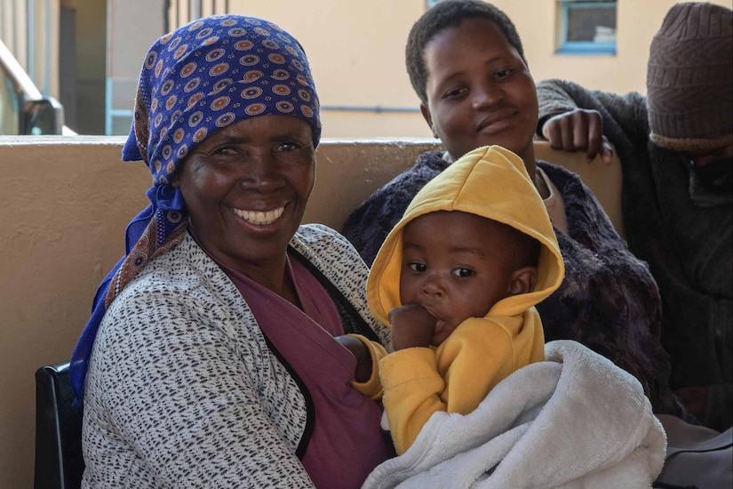 A mother holds a child at a clinic.