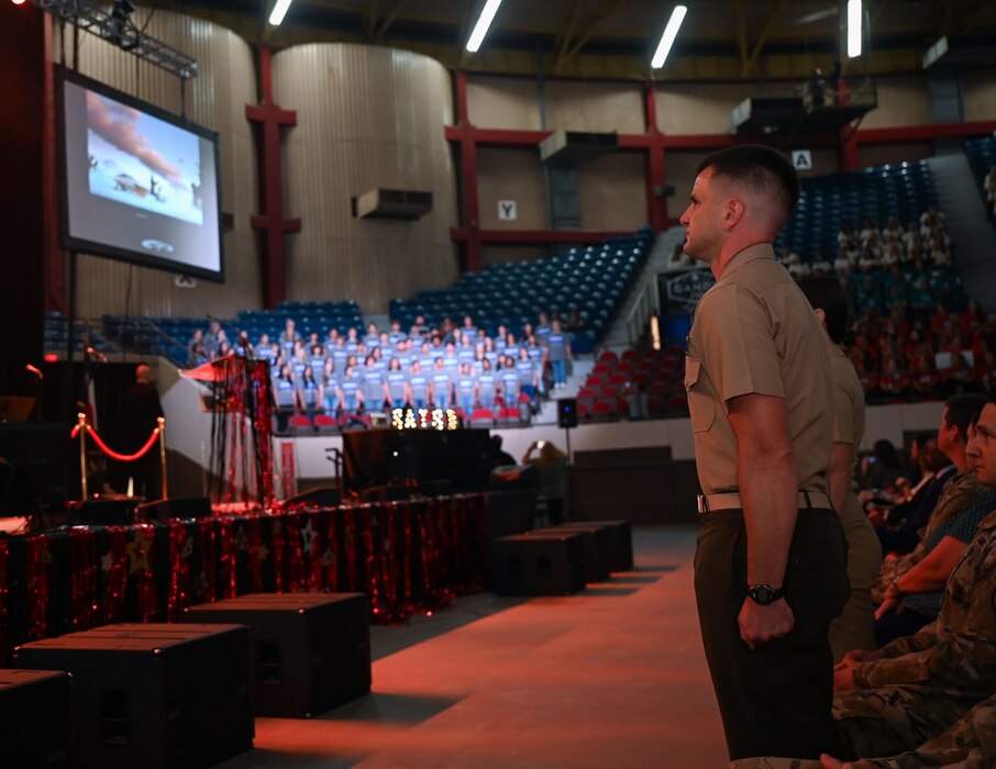 U.S. Marine Corps Lt. Col. Brian Meade, Marine Corps Detachment Goodfellow commander, stands at attention during the performance of the “Armed Forces Medley” at the 2024 San Angelo Independent School District Convocation at the Foster Communication Coliseum, San Angelo, Texas, Aug. 6, 2024. The SAISD combined choir featured faculty and students from multiple schools across the school district. (U.S. Air Force photo by Airman 1st Class Evelyn J. D’Errico)