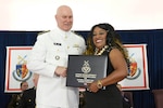 Two people stand together during an awards ceremony.