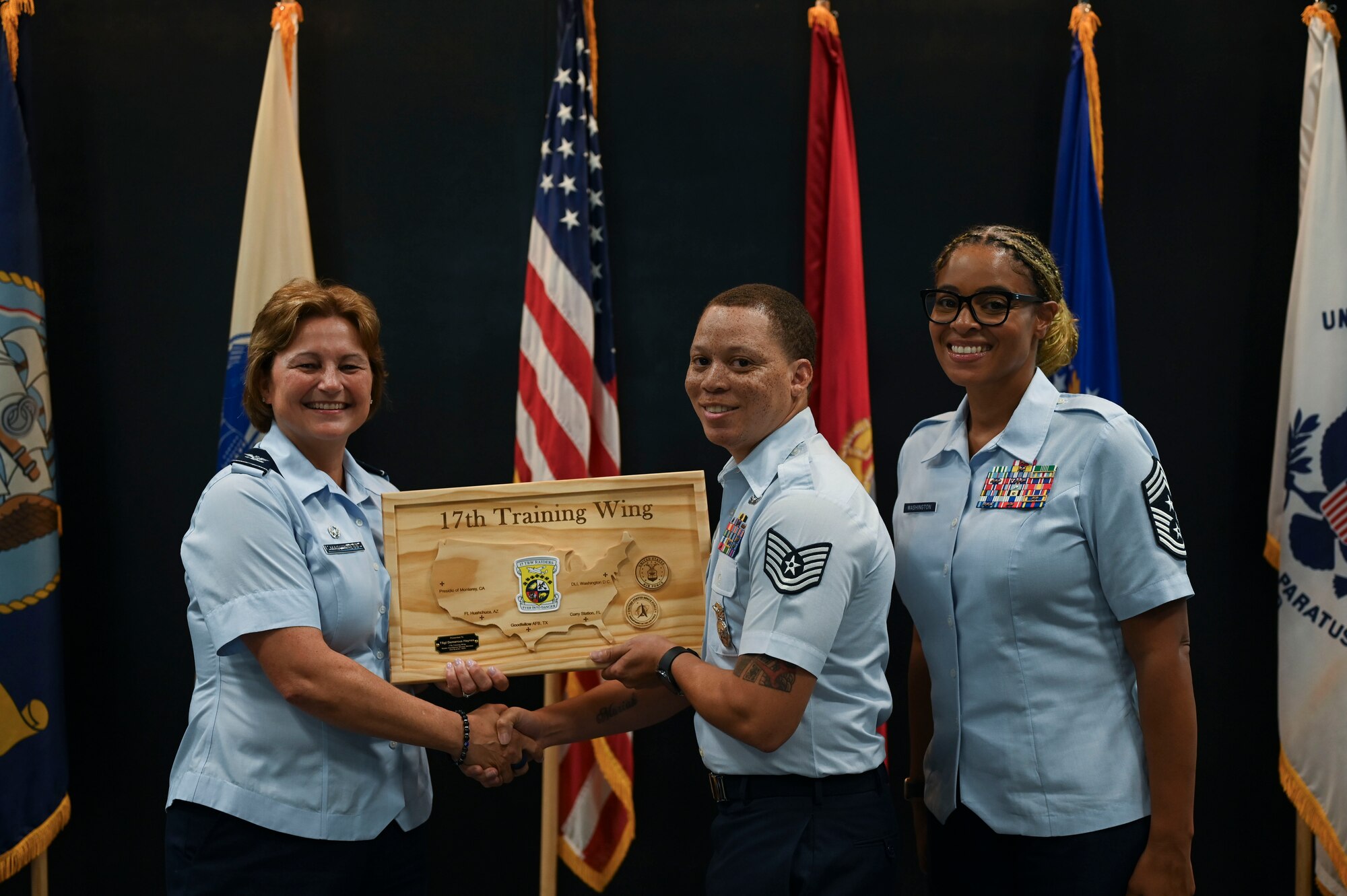 U.S. Air Force Col. Angelina Maguiness and Chief Master Sgt. Khamillia Washington, 17th Training Wing commander and command chief, presents the Raiders Excellence Service Member award to Technical Sgt. Demarcus Hanes during the 17th TRW 2nd Quarterly Awards Ceremony at the Powell Event Center, Goodfellow Air Force Base, Texas, Aug. 9, 2024. The Raiders Excellence Award is presented to high-performing service members from across the joint services.  (U.S. Air Force photo by Airman 1st Class Madi Collier)