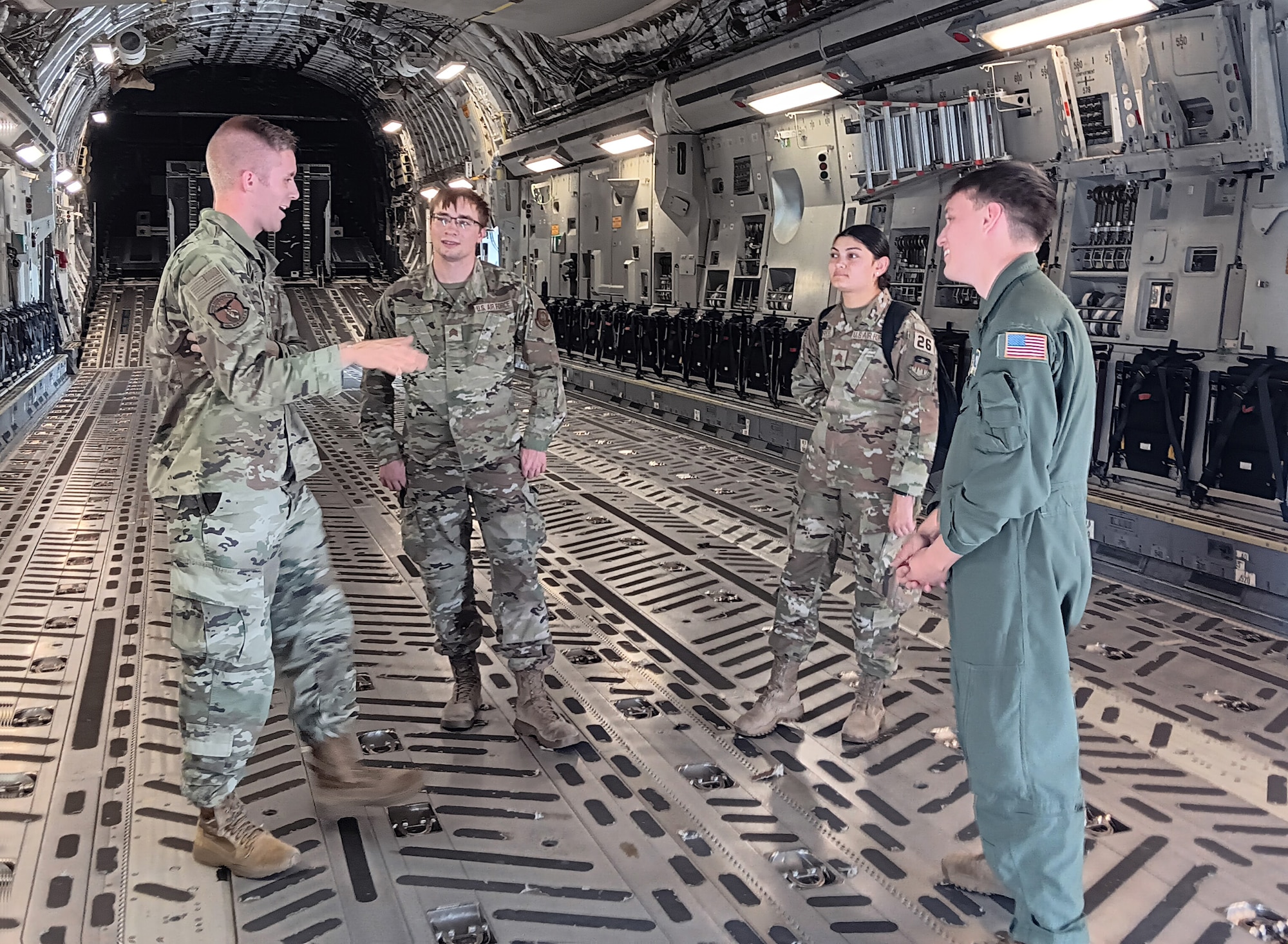 Capt. Eric Dolan, 445th Maintenance Squadron director of operations, (left) shares his experiences about being a maintenance officer in the Air Force Reserve to five Air Force Academy cadets during their tour of a 445th Airlift Wing C-17 Globemaster III July 26, 2024. Earlier during the visit, Senior Airman Diegan Rhodes (right), 89th Airlift Squadron loadmaster, explained his role as a loadmaster and the various missions he’s been a part of. (U.S. Air Force Photo by Stacy Vaughn)