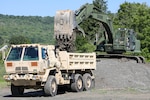New York Army National Guard Pfc. Keith Alvarado (operating the 10-ton dump truck) and Spc. Joseph Warner (operating the excavator), both assigned to 1156th Engineer Company, practiced operating skills Aug. 10, 2024, as part of the 204th Engineer Battalion's annual engineering rodeo in Walton, New York.