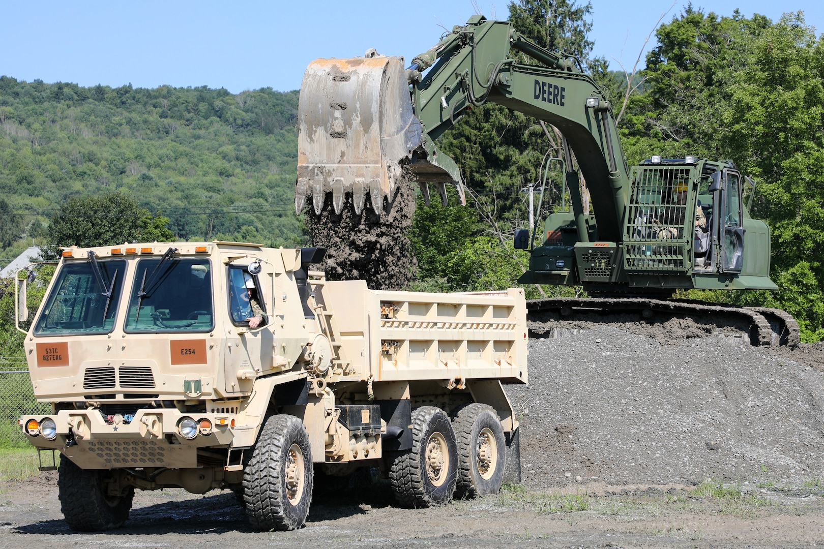 New York Army National Guard Pfc. Keith Alvarado (operating the 10-ton dump truck) and Spc. Joseph Warner (operating the excavator), both assigned to 1156th Engineer Company, practiced operating skills Aug. 10, 2024, as part of the 204th Engineer Battalion's annual engineering rodeo in Walton, New York.