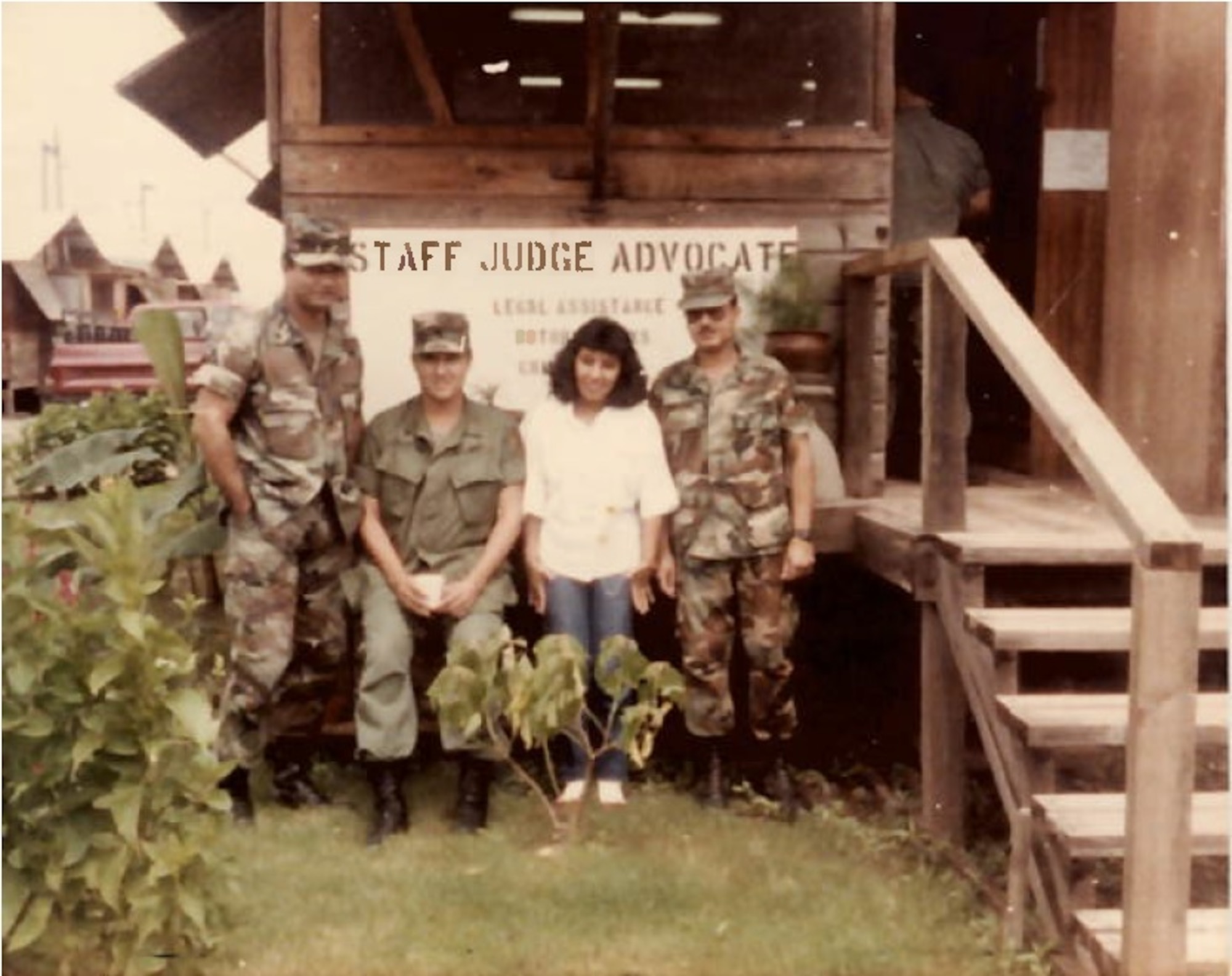 A photo of four people posing in front of an office.