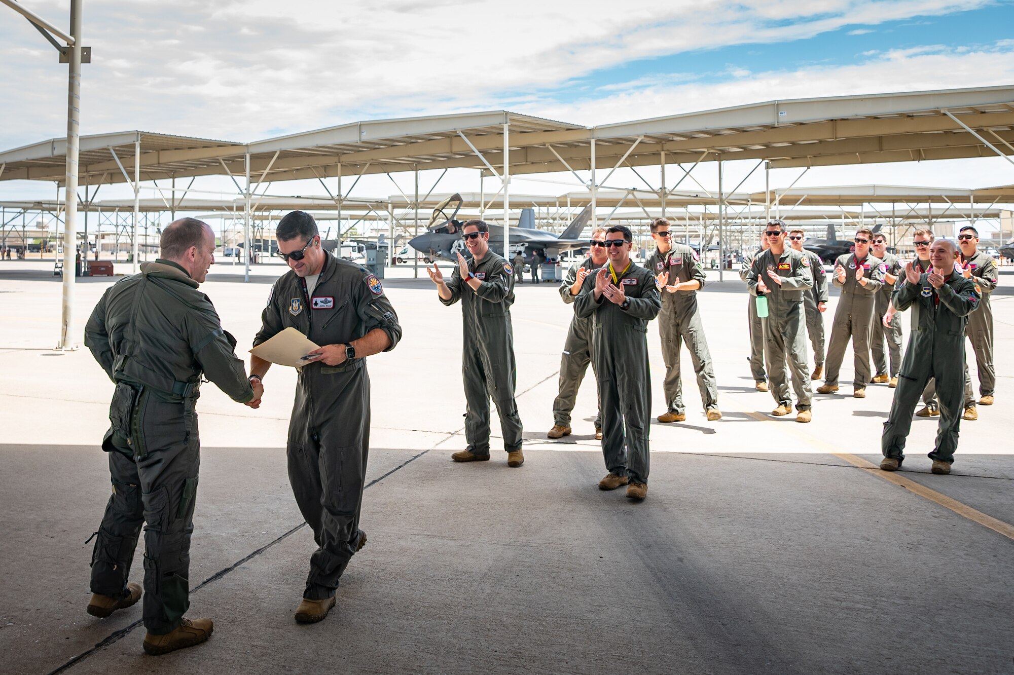 Reserve Citizen Airman Lt. Col. Christopher "Lube" Lowe, F-35 instructor pilot and 56th Operations Group deputy commander, is presented with a certificate commemorating his 1,000th flight hour in the F-35 Lightning II at Luke Air Force Base, Ariz., Aug. 9, 2024. Lowe's achievement reflects the culmination of years of dedication and support from the 944th Fighter Wing. (U.S. Air Force photo by Tech. Sgt. Tyler J. Bolken)