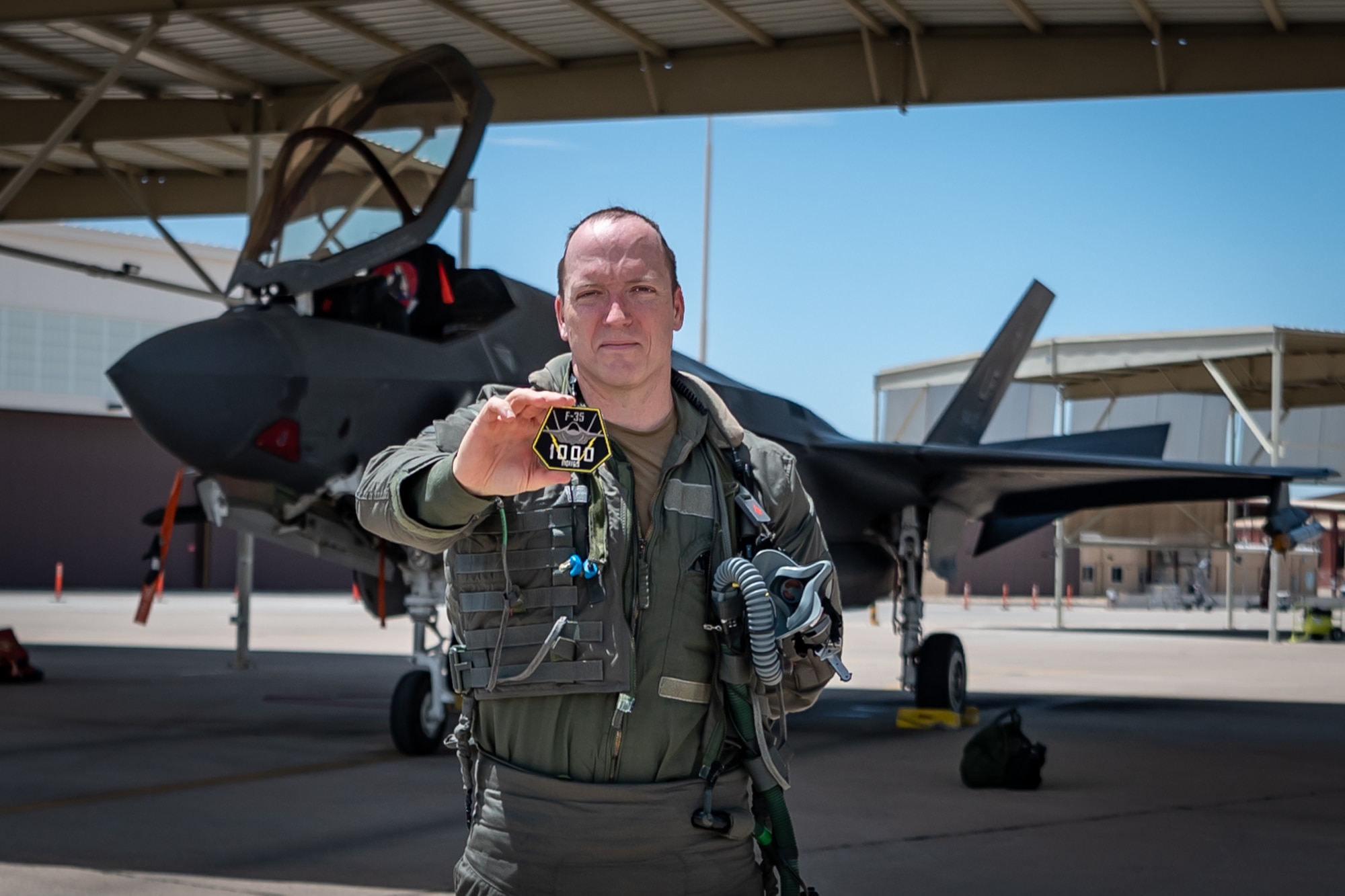 Reserve Citizen Airman Lt. Col. Christopher "Lube" Lowe, an F-35 instructor pilot and the 56th Operations Group deputy commander, proudly displays a special patch commemorating his 1,000th flight hour in the F-35 Lightning II at Luke Air Force Base, Ariz., Aug. 9, 2024. Lowe is one of only five members in the 944th Fighter Wing to reach this milestone, underscoring his commitment and the collective efforts of the Airmen who support every mission. (U.S. Air Force photo by Tech. Sgt. Tyler J. Bolken)