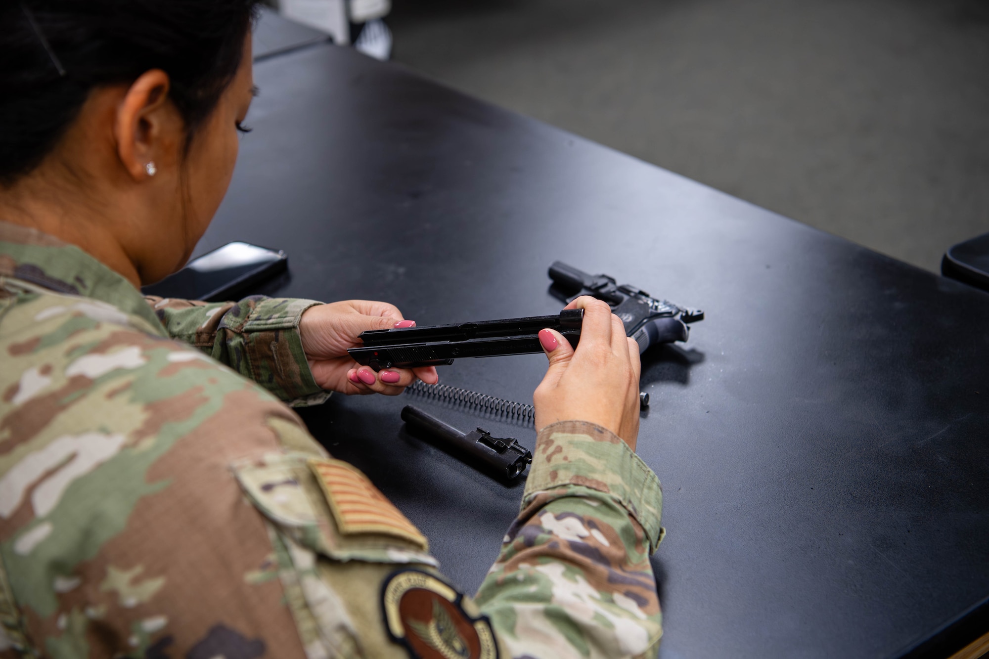 U.S. Air Force Maj. Melody Chong, 374th Logistics Readiness Squadron director of operations, assembles an M9 pistol during a Combat Arms Training and Maintenance course at Yokota Air Base, Japan.