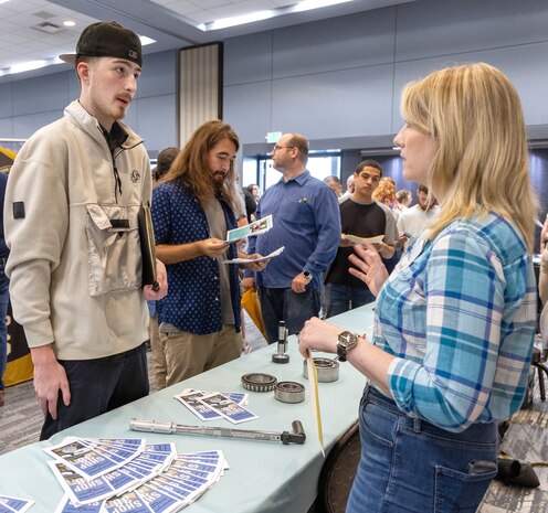 Tina Anderson, hiring, promotion and apprenticeship manager, Shop 38, Marine Machinist, talks about current job opportunities with a local job seeker during the Puget Sound Naval Shipyard & Intermediate Maintenance Facility Hiring Fair Aug. 9, 2024, at the Kitsap Conference Center in downtown, Bremerton, Washington. (U.S. Navy photo by Wendy Hallmark)