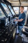 Tyler George, production general foreman, Code 760, Regional Dive Division at Puget Sound Naval Shipyard & Intermediate Maintenance Facility in Bremerton, Washington, pilots the dive locker's new purpose-built dive boat out of the Controlled Industrial Area enroute to the Port Orchard, Washington, Marina, Aug. 1, 2024. (U.S. Navy photo by Jeb Fach)