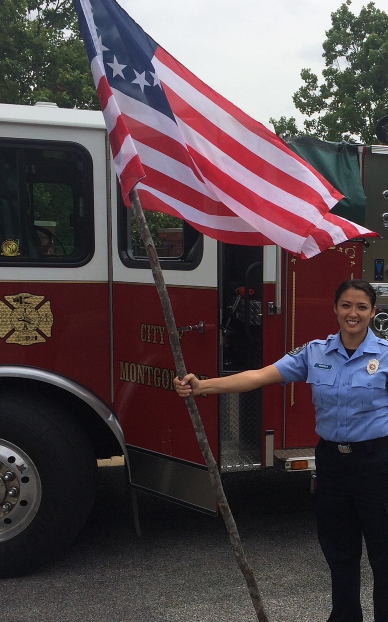 MSgt Cynthia Webster stands with the American flag at an outreach event hosted by the Montgomery, Ala. fire department.