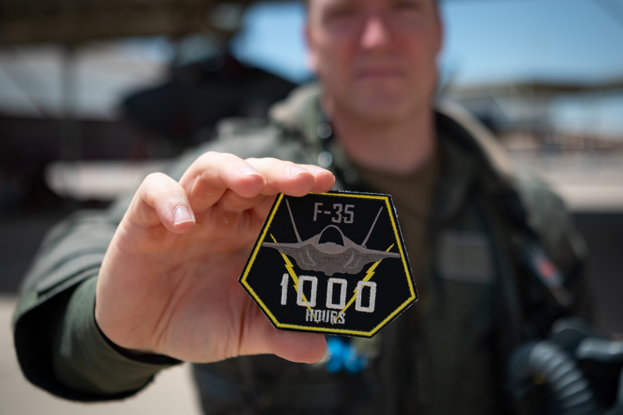 Reserve Citizen Airman Lt. Col. Christopher "Lube" Lowe, an F-35 instructor pilot and the 56th Operations Group deputy commander, proudly displays a special patch commemorating his 1,000th flight hour in the F-35 Lightning II at Luke Air Force Base, Ariz., Aug. 9, 2024. Lowe is one of only five members in the 944th Fighter Wing to reach this milestone, underscoring his commitment and the collective efforts of the Airmen who support every mission. (U.S. Air Force photo by Tech. Sgt. Tyler J. Bolken)