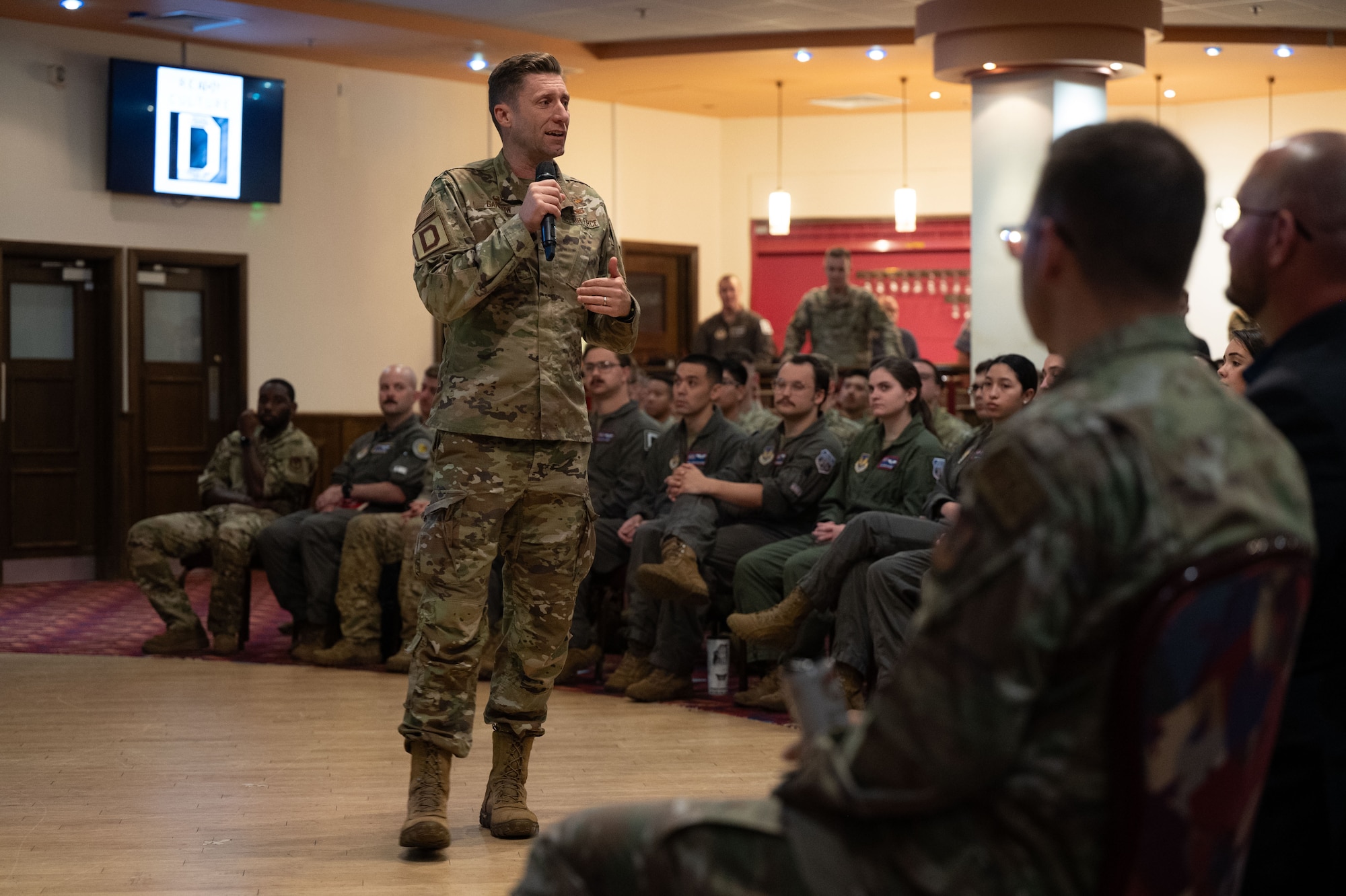 U.S. Air Force Col. Ryan Garlow, 100th Air Refueling Wing commander, speaks to Airmen on the topics of culture, organization and feedback during an all-call that finished with a Q&A at Royal Air Force Mildenhall, England, Aug. 8, 2024.