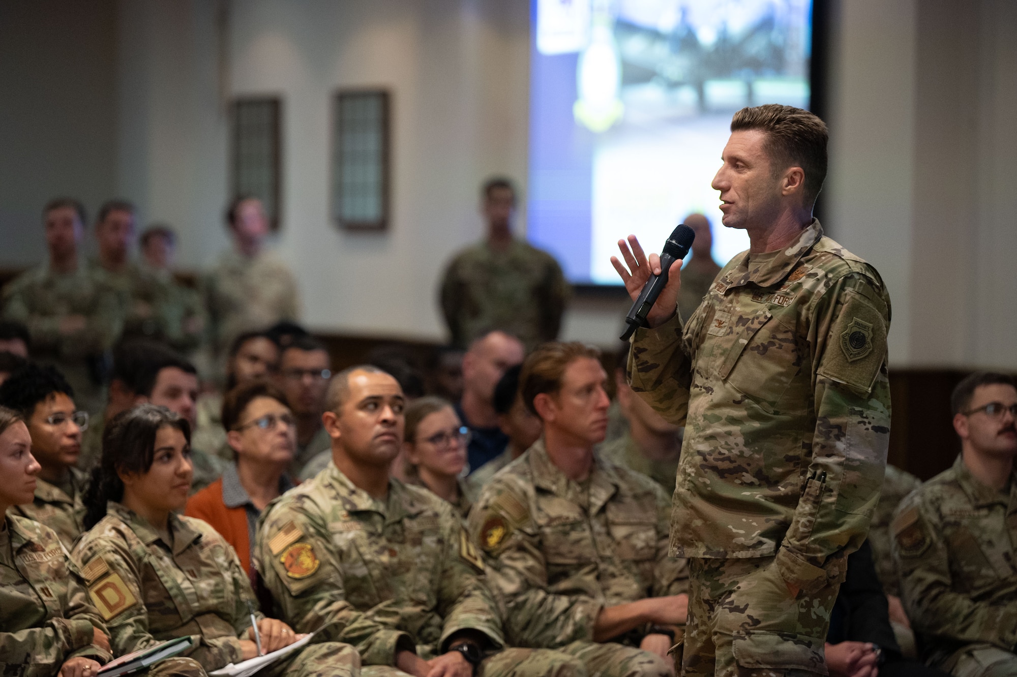 U.S. Air Force Col. Ryan Garlow, 100th Air Refueling Wing commander, speaks to Airmen on the topics of culture, organization and feedback during an all-call that finished with a Q&A at Royal Air Force Mildenhall, England, Aug. 8, 2024.