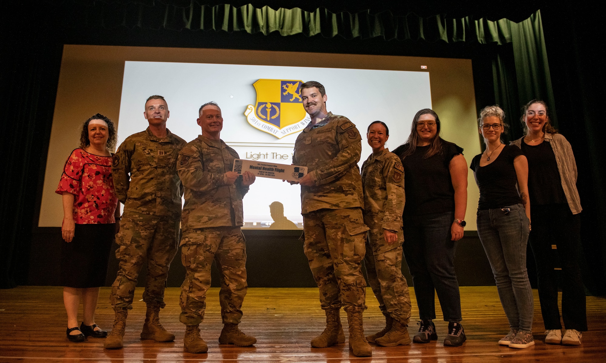 Col. D. Landon Phillips, 501st Combat Support Wing commander, center left, presents an award to the Mental Health Flight at RAF Alconbury, England, Aug. 9, 2024. This award presentation was part of an all call hosted by Phillips at RAF Alconbury.