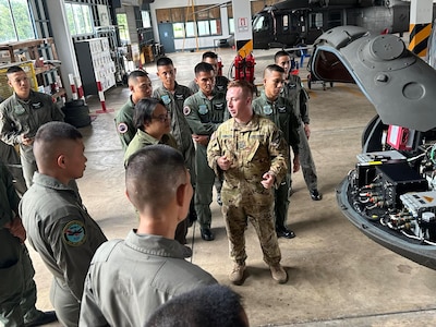 Chief Warrant Officer 2 Chris Cuddington, pilot, 1st Battalion, 168th General Support Aviation, talks with his counterparts from the 9th Aviation Battalion during an aviation subject matter expert exchange in Lop Buri, Thailand, July 31, 2024.